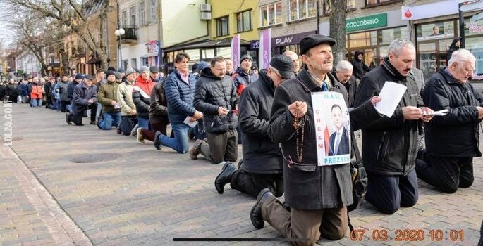 polityka : Modlitwa i klęczenie ze zdjęciem Andrzeja Dudy w centrum miasta?