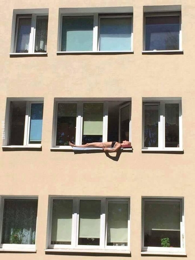 WOW : Dziewczyna opala się na parapecie za oknem