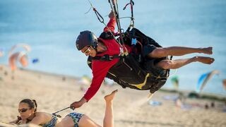 Paralotniarz odpina stanik na plaży