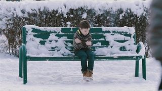 Chłodna reakcja na Chłopiec bez kurtki na ławce