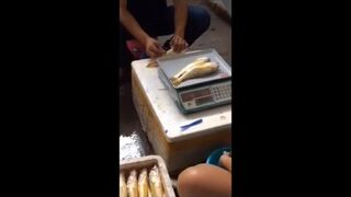 Chiński sprzedawca wstrzykuje wodę w ryby