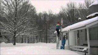 Facet stara się usunąć śnieg z dachu