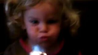 Dziewczynka usiłuje zgasić świeczkę