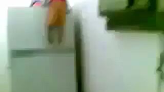 Dzieciak wspina się po lodówce z samochodem